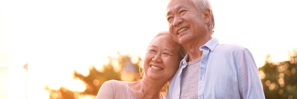 Older couple hugging outside at dusk