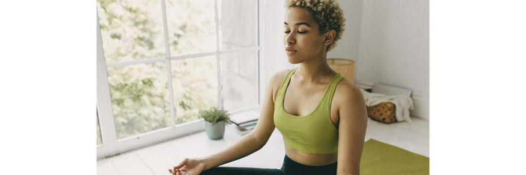 woman by the window doing yoga